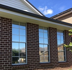 TMC Tinting residential window tinting Sydney — ceramic solar control film on modern two storey home large glass windows and sliding doors