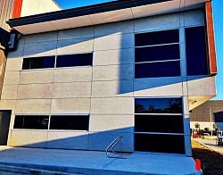 commercial building exterior: TMC Tinting commercial window tinting Sydney — solar control film on multi-storey building at factory complex prestons