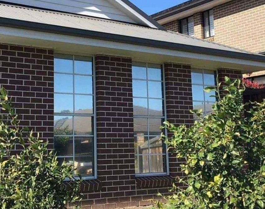 TMC Tinting residential window tinting Sydney — reflective solar control film installed on brick home southwest Sydney