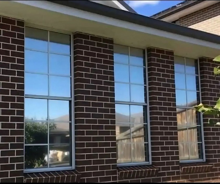 TMC Tinting residential window tinting Sydney — reflective solar control film installed on brick home